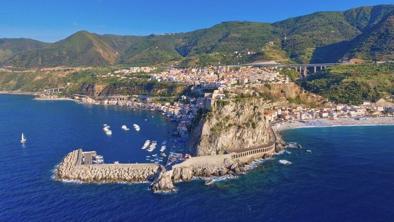 © Istockphoto  | Il panorama dello Stretto di Messina. Cariddi si trova a sinistra, ed è riconoscibile grade al suo iconico traliccio elettrico in disuso: di fronte, sulla costa calabrese si vede Scilla