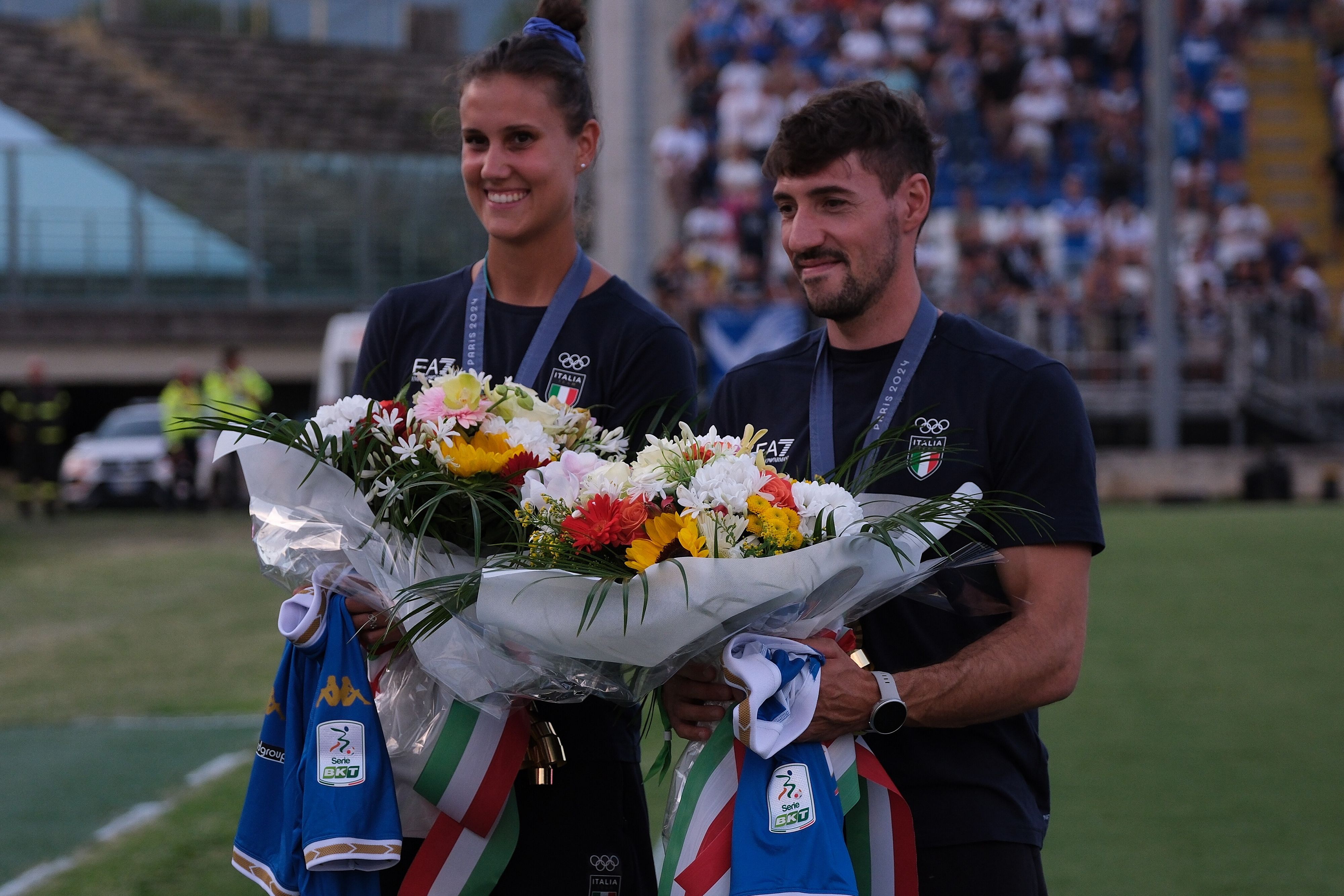 © IPA  | In occasione dell'esordio di campionato di Serie B tra Brescia e Palermo, prima del fischio d'inizio, lo stadio Mario Rigamonti di Brescia ha festeggiato due delle tre medaglie d'oro olimpiche bresciane targate Roncadelle. Sul prato dello stadio sono scesi Anna Danesi e Giovanni De Gennaro omaggiati di un mazzo di fiori dal capitano del Brescia Dimitri Bisoli e il vice Andrea Cistana.