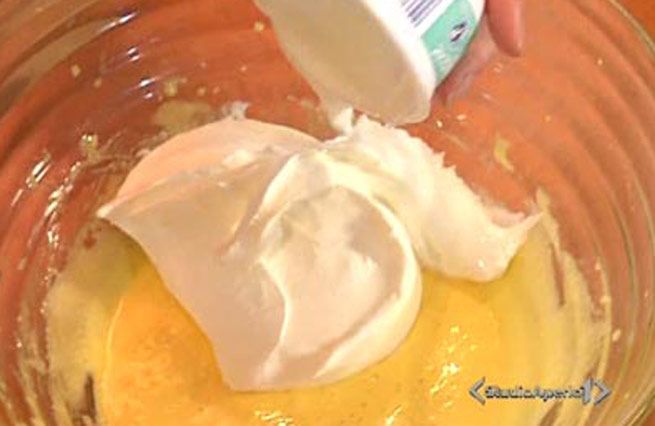 © Da video | Sbattere due tuorli con 4 cucchiai di zucchero, quindi aggiungere 250 g. di mascarpone o (se preferite) ricotta