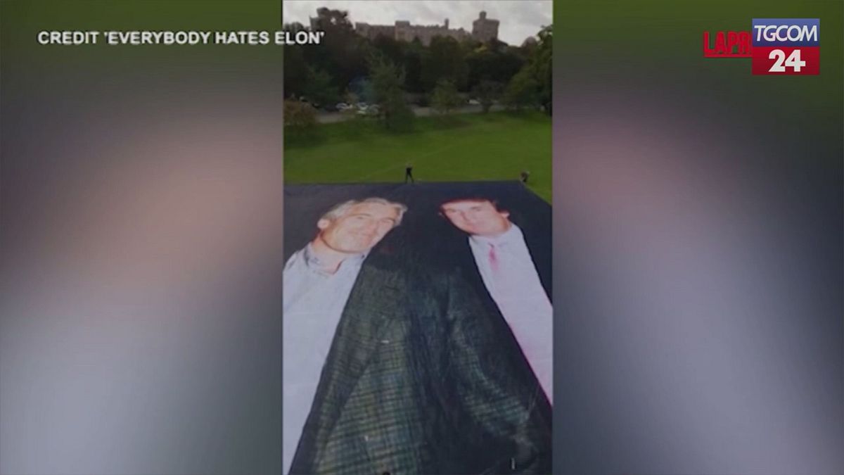 Windsor, attivisti srotolano uno striscione che raffigura Donald Trump con Epstein