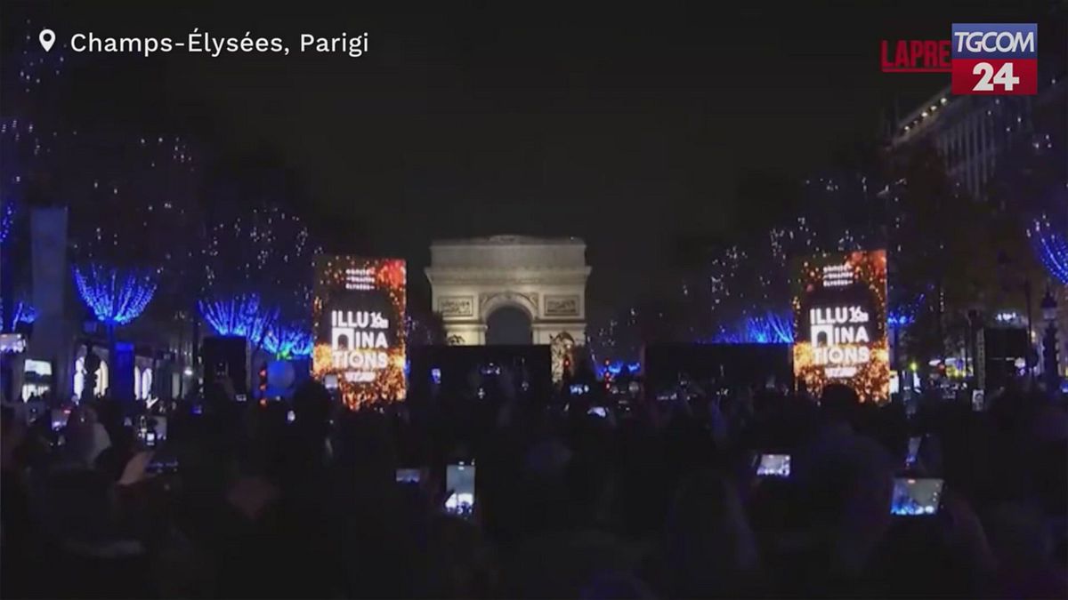 Parigi, si illuminano gli Champs-Élysées: folla in festa