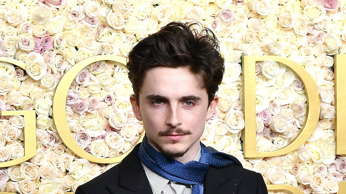 Il look di Timothée Chalamet per la serata di assegnazione dei Golden Globe Awards: sciarpa di seta azzurra al posto della cravatta o del papillon