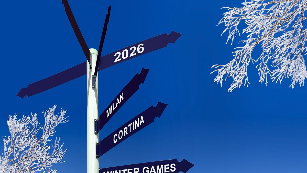 2026 Milan Cortina winter games written on direction signs, snowy trees, winter olympics celebration