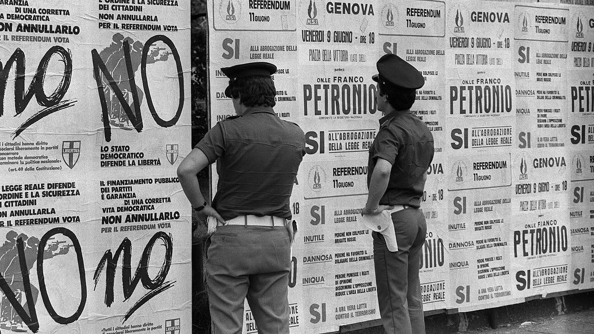 Agenti di polizia davanti ai manifesti per i referendum sul finanziamento dei partiti