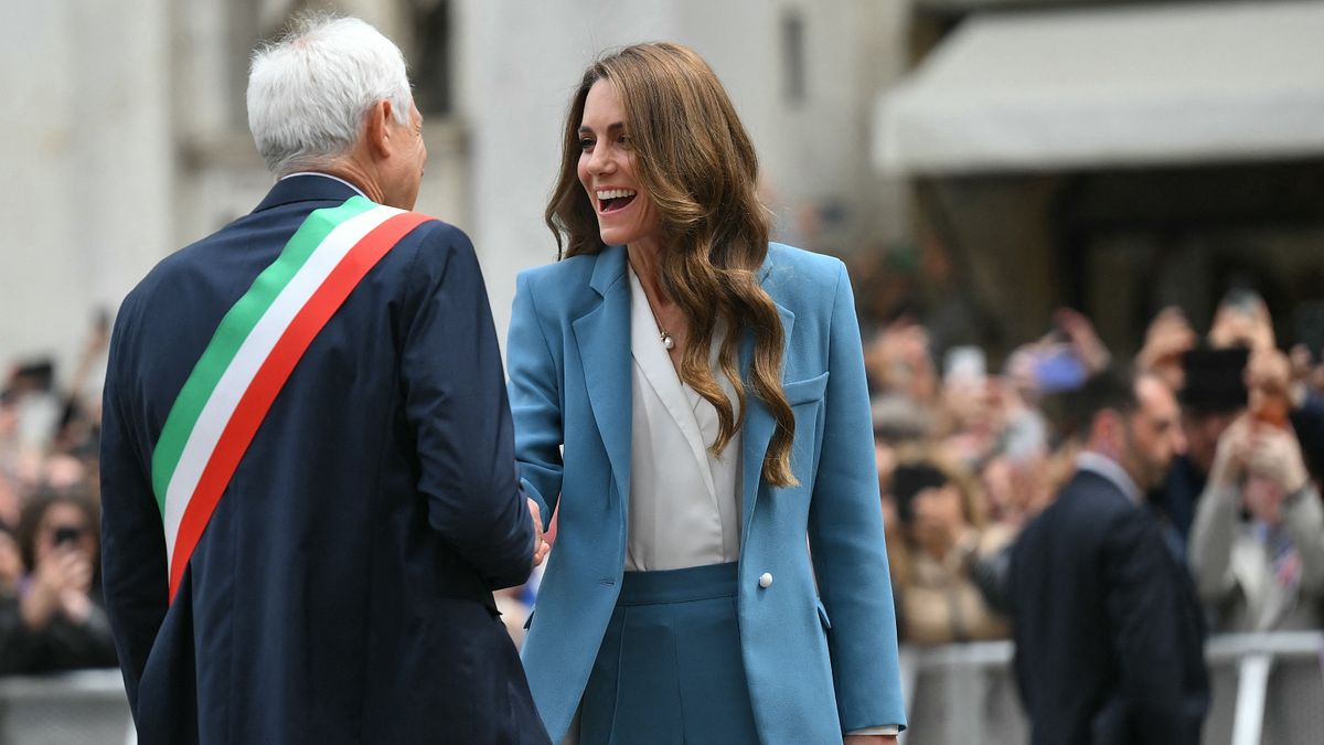 Blazer e pantalone, il look della principessa del Galles Catherine, Kate Middleton, al suo arrivo a Reggio Emilia (qui con il sindaco Marco Massari a darle il benvenuto)