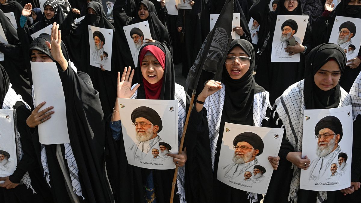 Pakistani espongono poster del defunto leader supremo Ali Khamenei per condannare l'attacco di Stati Uniti e Israele all'Iran, durante una protesta a Lahore
