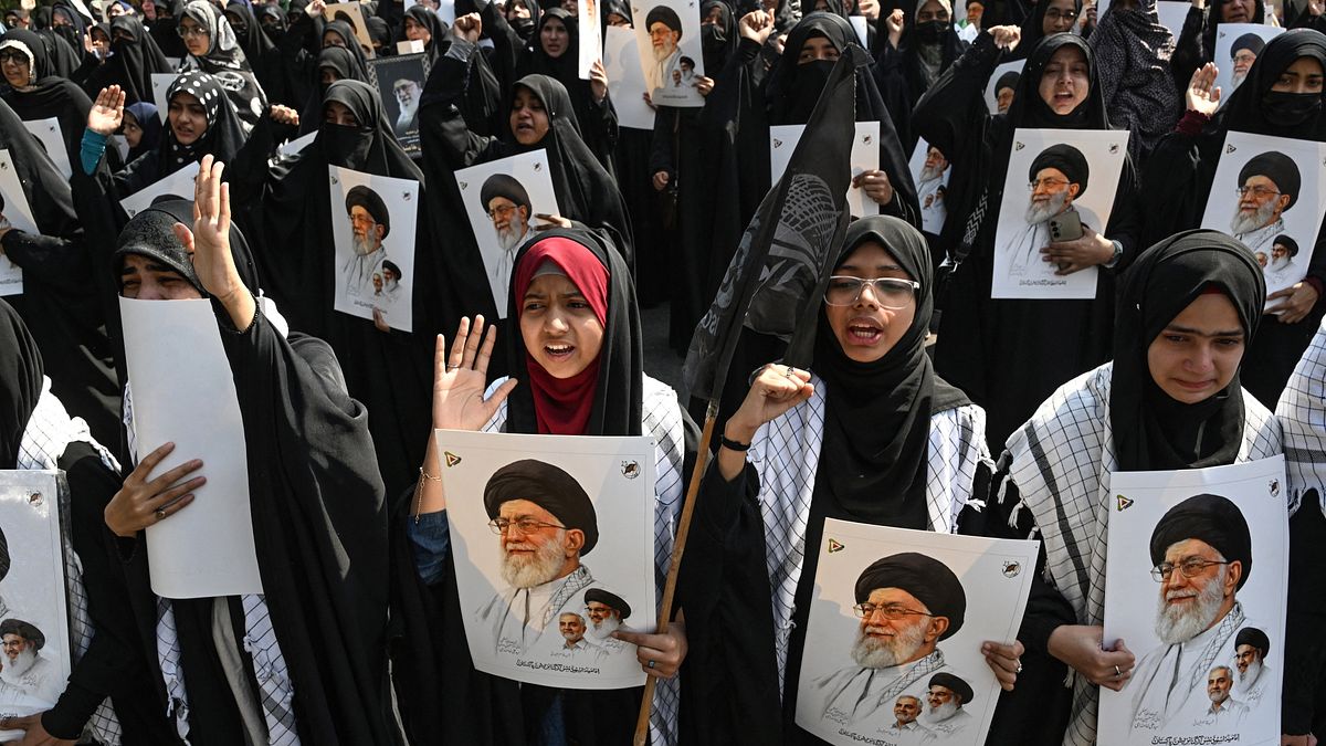 Pakistani espongono poster del defunto leader supremo Ali Khamenei per condannare l'attacco di Stati Uniti e Israele all'Iran, durante una protesta a Lahore