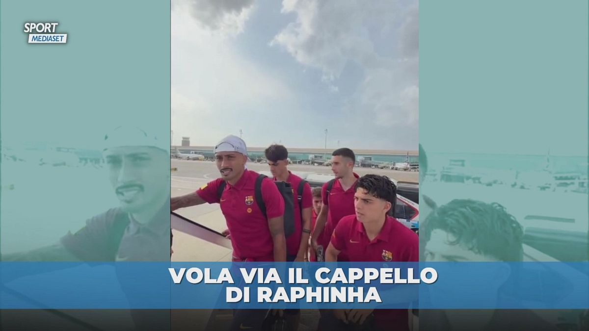 Raphinha in fila per l'ingresso nell'aereo e il cappello vola via