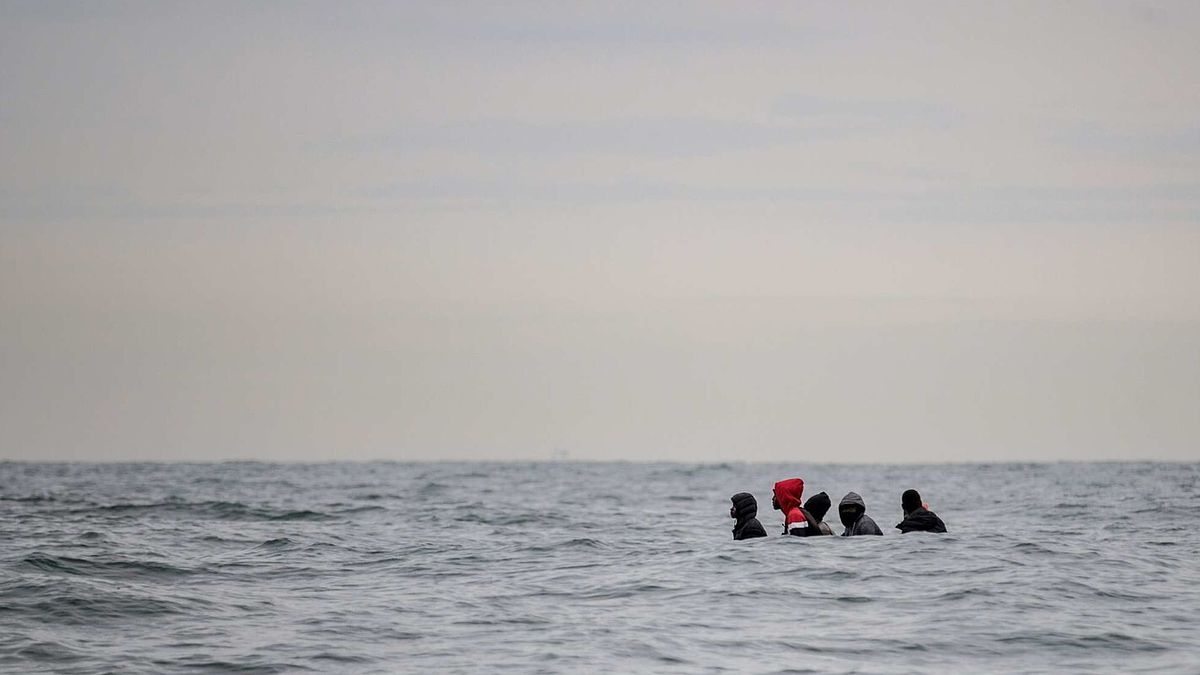 Migranti siedono a bordo di un barcone che naviga in acque agitate tra Sangatte e Cap Blanc-Nez (Capo Naso Bianco), nella Manica al largo delle coste del nord della Francia, mentre tentano di attraversare i confini marittimi tra Francia e Regno Unito il 27 agosto 2020 