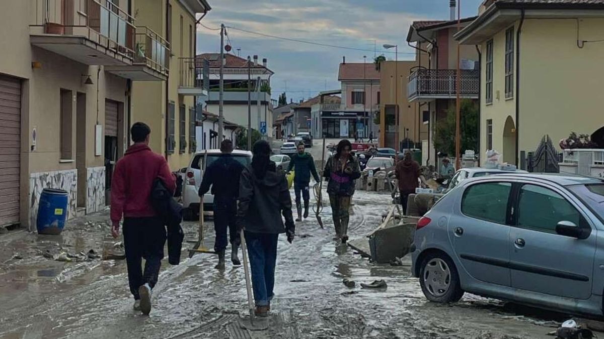 Cittadini ripuliscono le strade a Cesena dopo l'esondazione del Savio