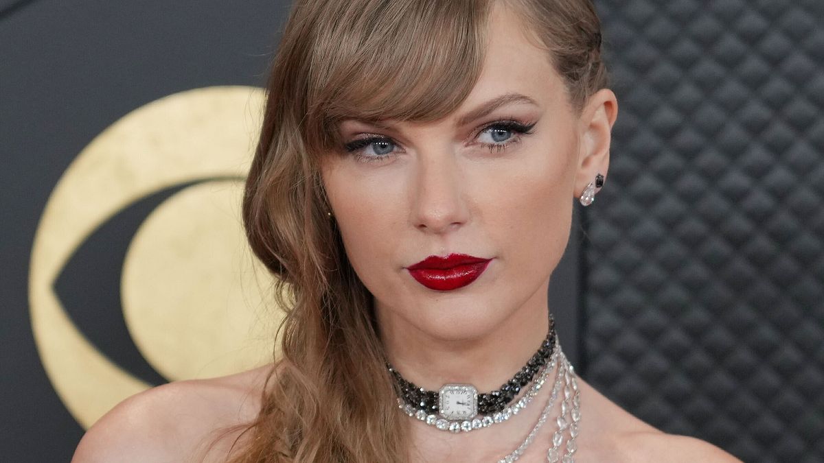 Taylor Swift con labbra rosse, cat-eye e treccina sul red carpet dei Grammy 2024 © IPA