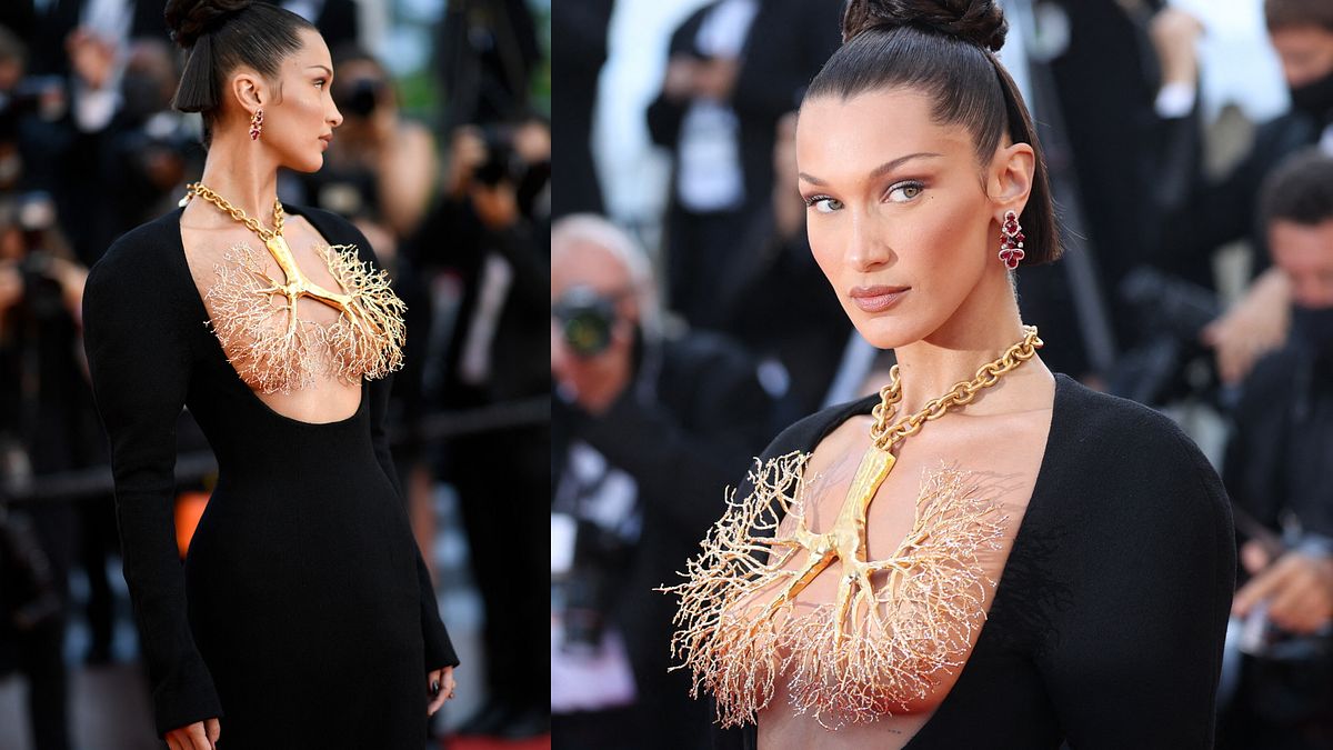 Bella Hadid con una creazione Schiaparelli by Daniel Roseberry a Cannes 2021: abito nero lungo che lascia scoperto il seno e collana dorata con maxi ciondolo a forma di polmoni © Afp