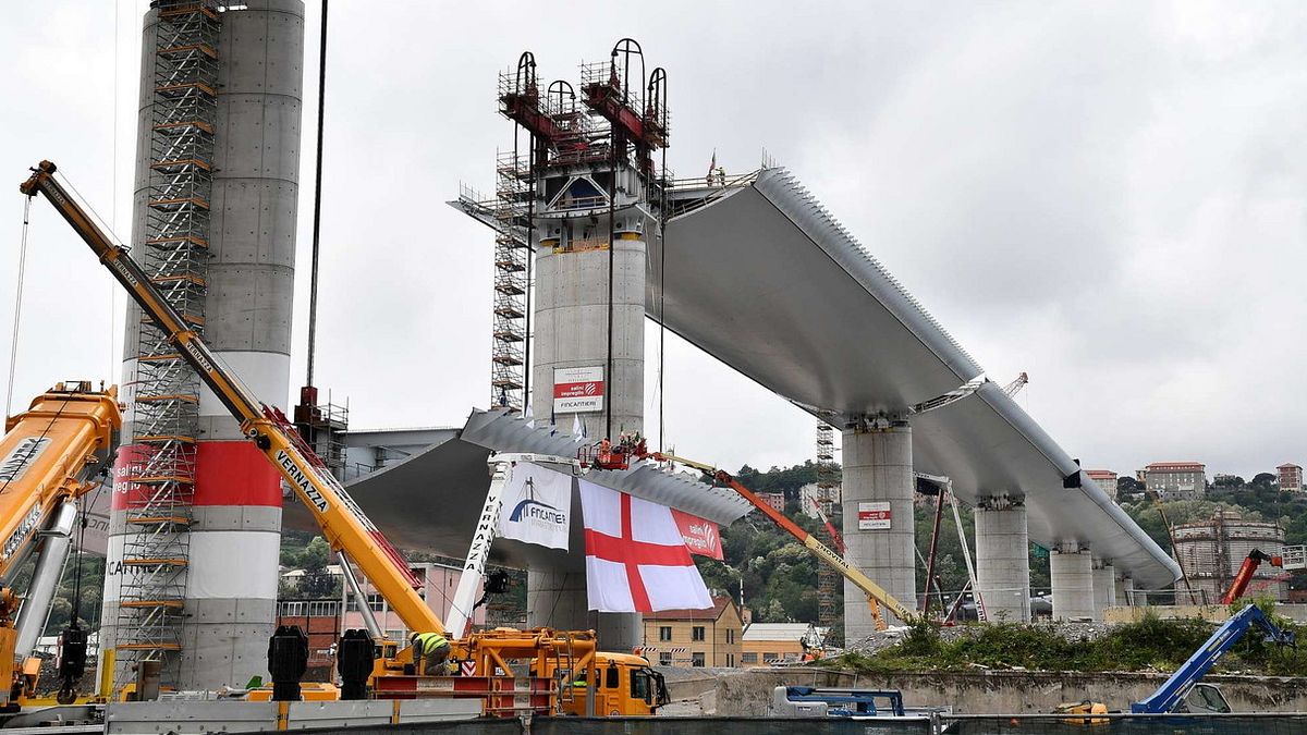 L'ultima campata del ponte Morandi pronta per essere posizionata. Su di essa è stata posta una bandiera con la Croce di San Giorgio, simbolo della città  © Ansa