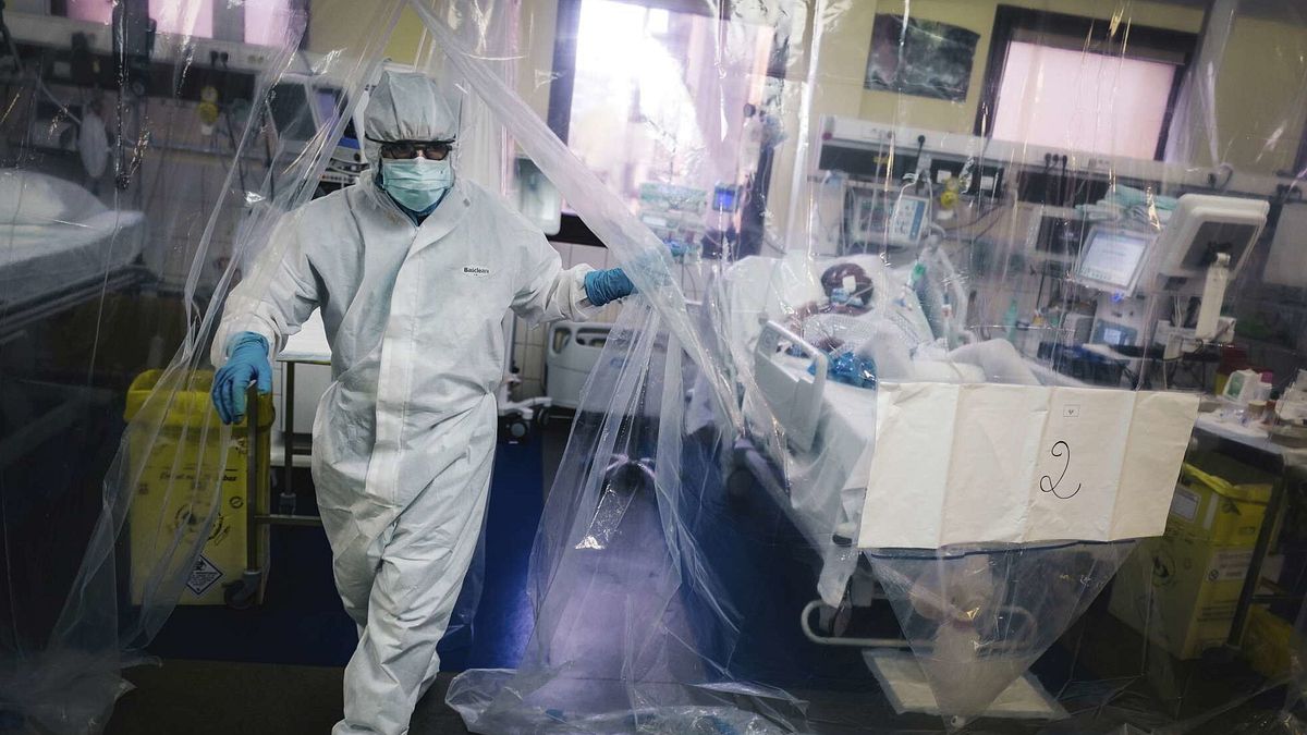 Un membro dello staff medico esce da una stanza protetta da un telone trasparente dopo essersi preso cura di un paziente infettato da COVID-19 nell'unità di terapia intensiva dell'ospedale Franco-Britannique di Levallois-Perret, Parigi, il 9 aprile 2020  © Afp