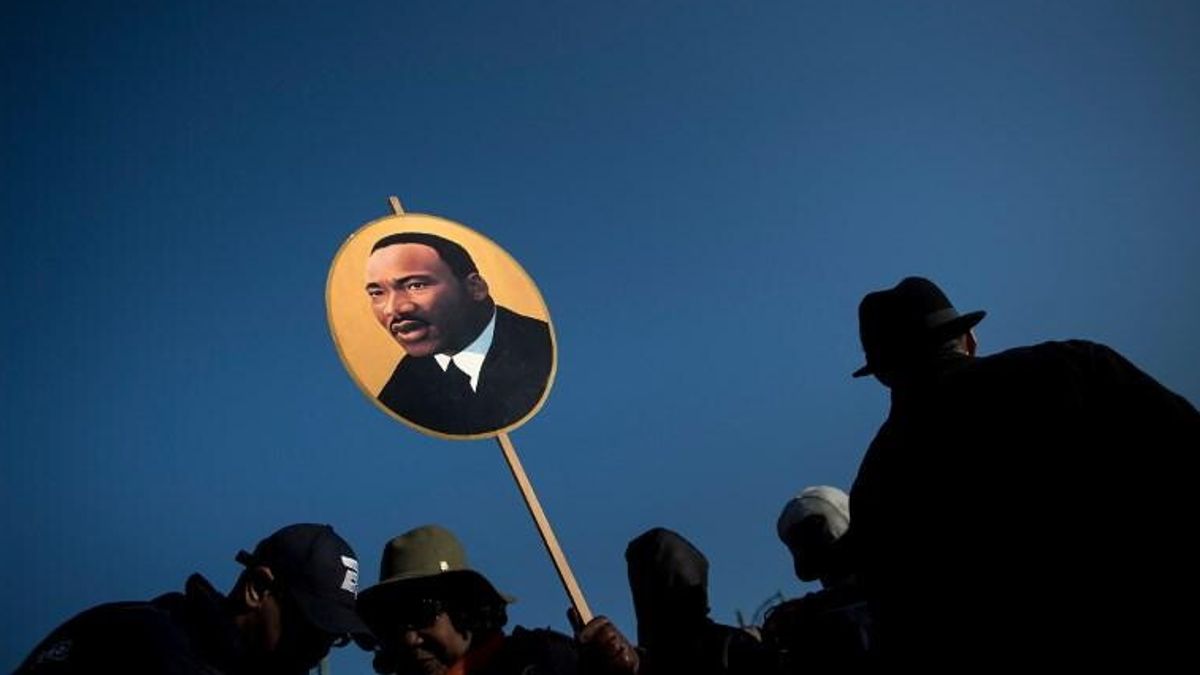 Una donna tiene un poster di Martin Luther King Jr. nel 50 ° anniversario del suo assassinio il 4 aprile 2018 a Memphis, nel Tennessee. © -afp