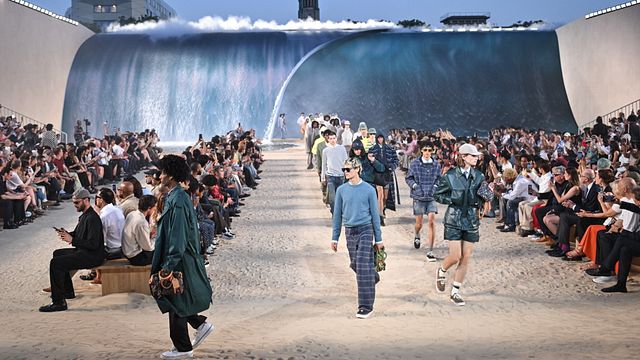 © IPA | I modelli nel finale della sfilata Louis Vuitton uomo primavera estate 2027. Il set riproduceva una spiaggia di sabbia sovrastata dalle onde del mare
