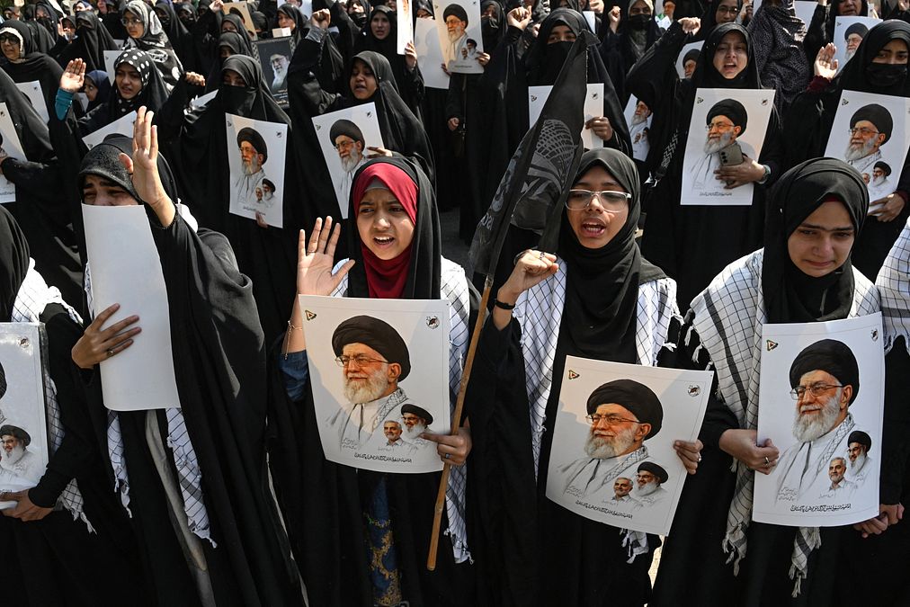 © Afp  |  I membri della comunità iraniana tengono in mano bottiglie di spumante durante una manifestazione a Sydney, in Australia 