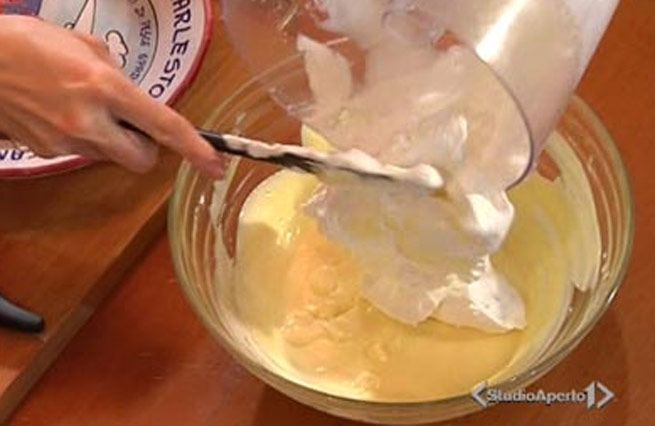 © Da video  | Sbattere due tuorli con 4 cucchiai di zucchero, quindi aggiungere 250 g. di mascarpone o (se preferite) ricotta