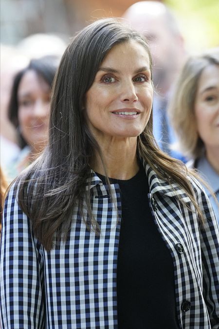 © IPA  | Lo stile di Letizia di Spagna: cappottino leggero Vichy, tracollina nera e scarpe Mary Jane per la sua visita alla Cuesta de Moyano, la fiera permanente del libro di Madrid