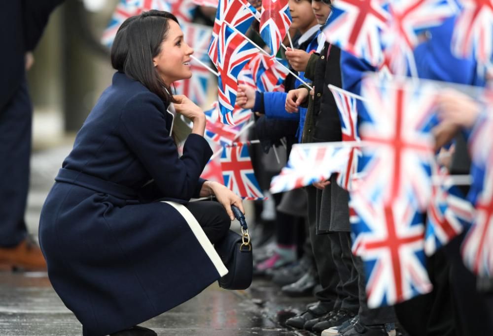 Meghan Markle abbraccia una bambina, sfidando il protocollo reale