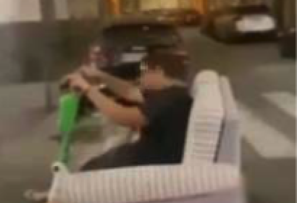 Sfreccia sul monopattino con un divano