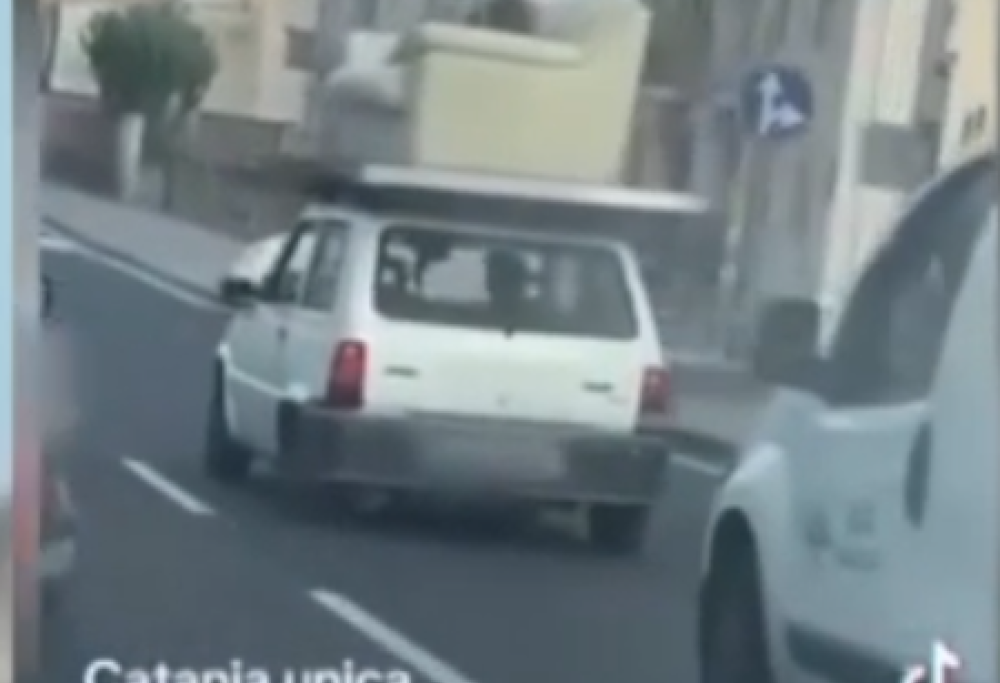 Uomo sdraiato sul divano sul tetto di una Panda