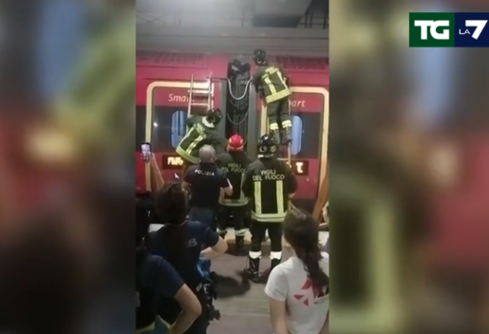 Viaggia sul soffietto che unisce i due vagoni del treno