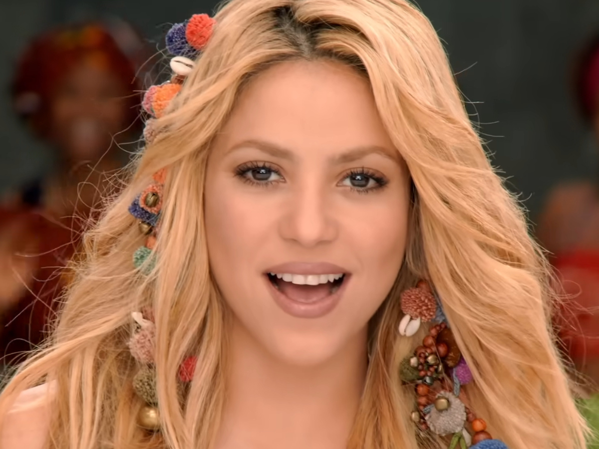 Close-up of a smiling blonde woman wearing colorful beaded floral hair accessories in her hairened look of a festive style.