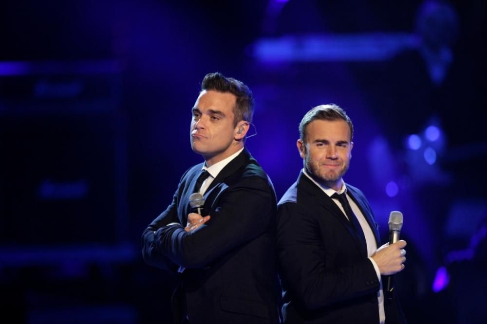 Robbie Williams e Gary Barlow cantano insieme e lasciano il palco mano nella mano
