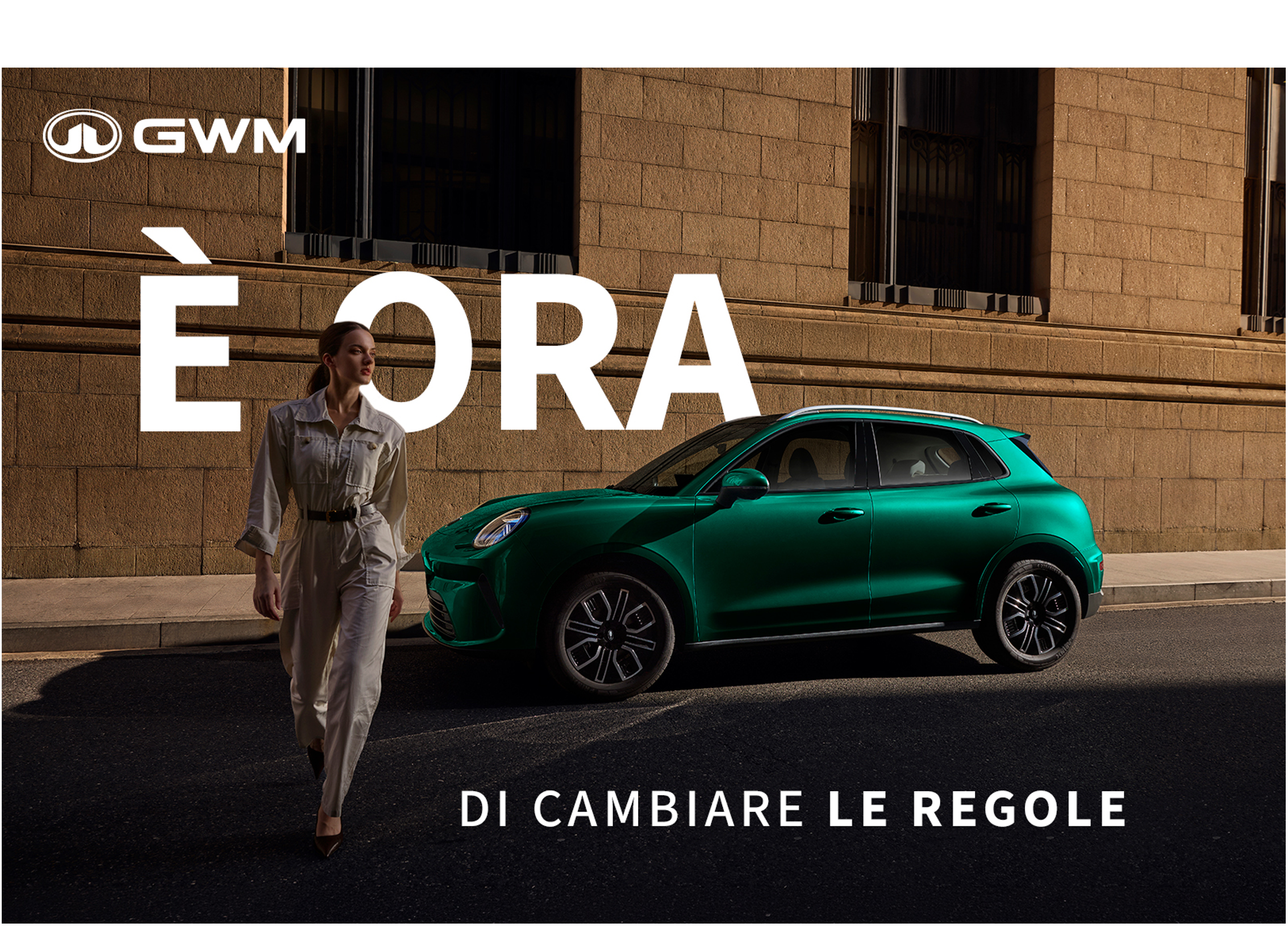 GWM ad banner with a woman in beige walking beside a green car, large white text 'EDRA' across a stone building backdrop and slogan below.