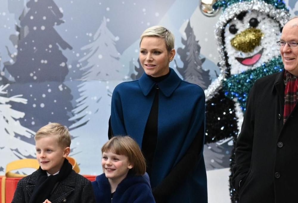 La Principessa Charlene sorridente distribuisce i doni di Natale